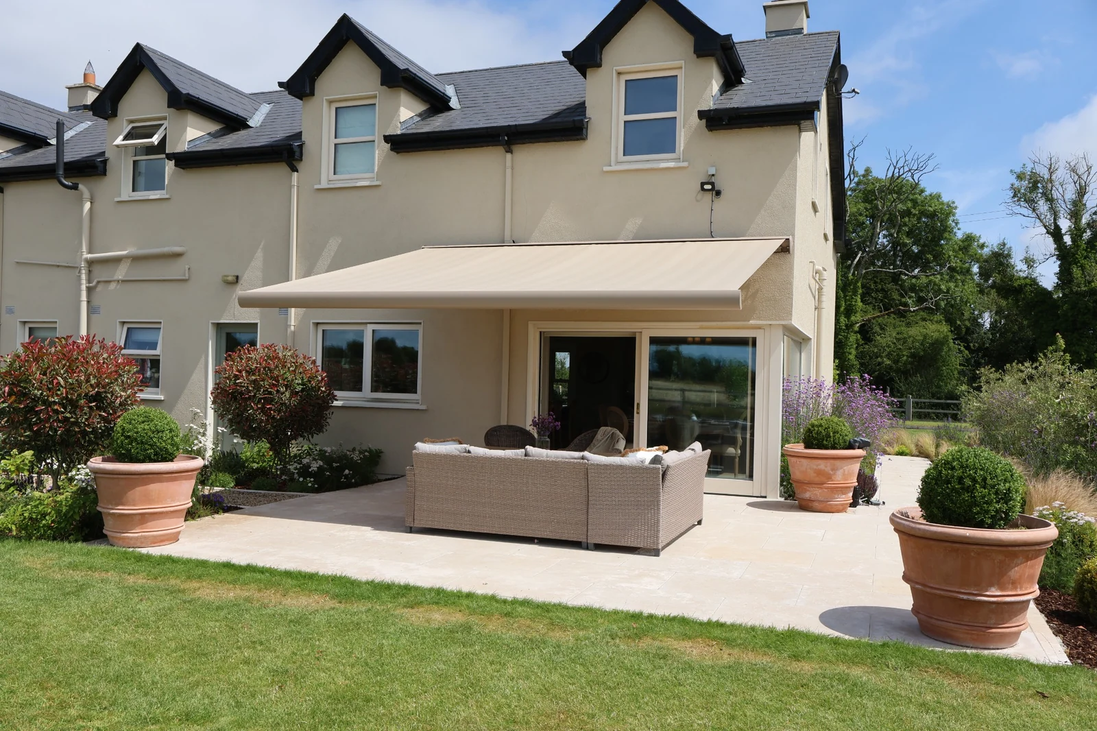 Cream retractable full cassette awning over a furnished garden terrace